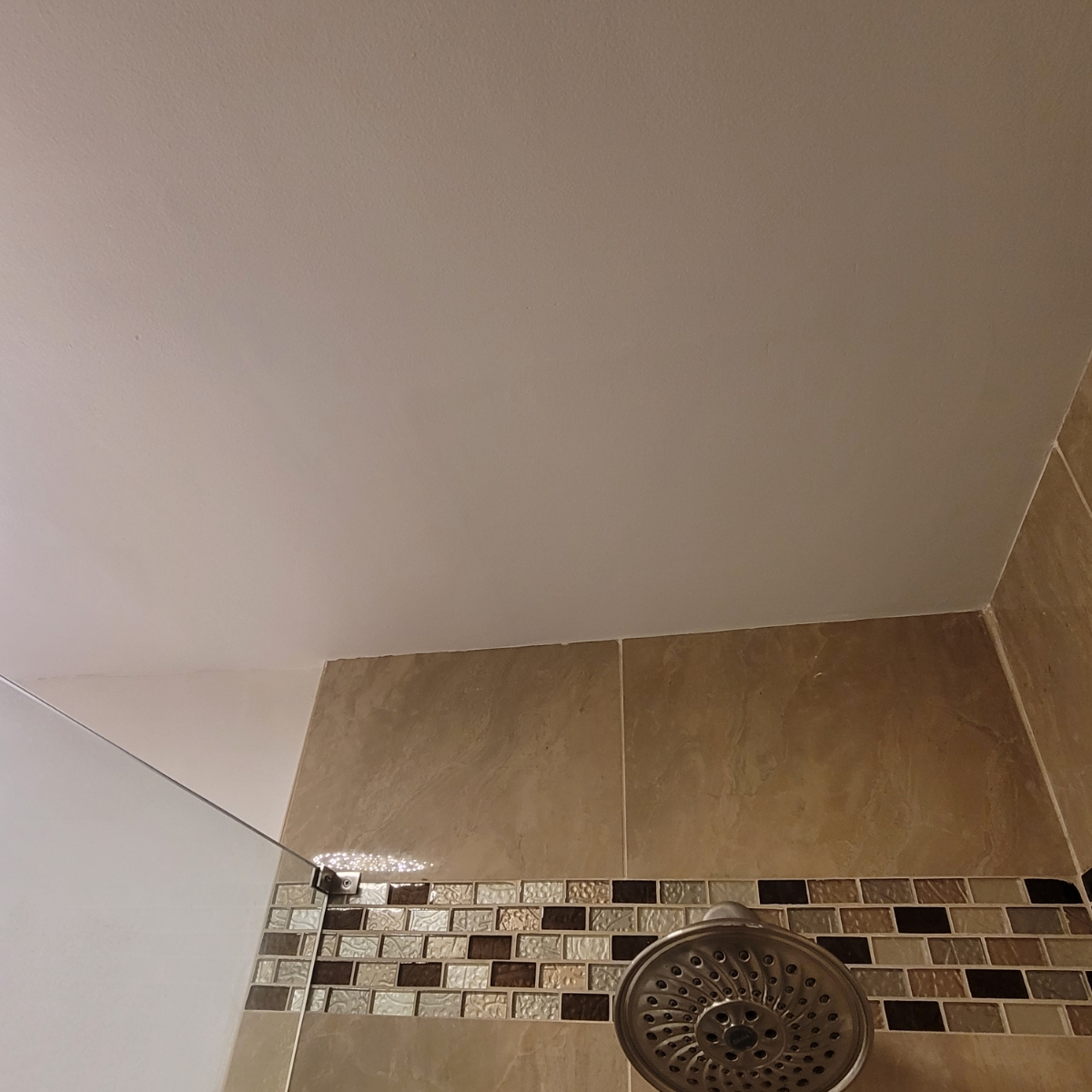Repaired bathroom ceiling above the tiled shower in Clinton.