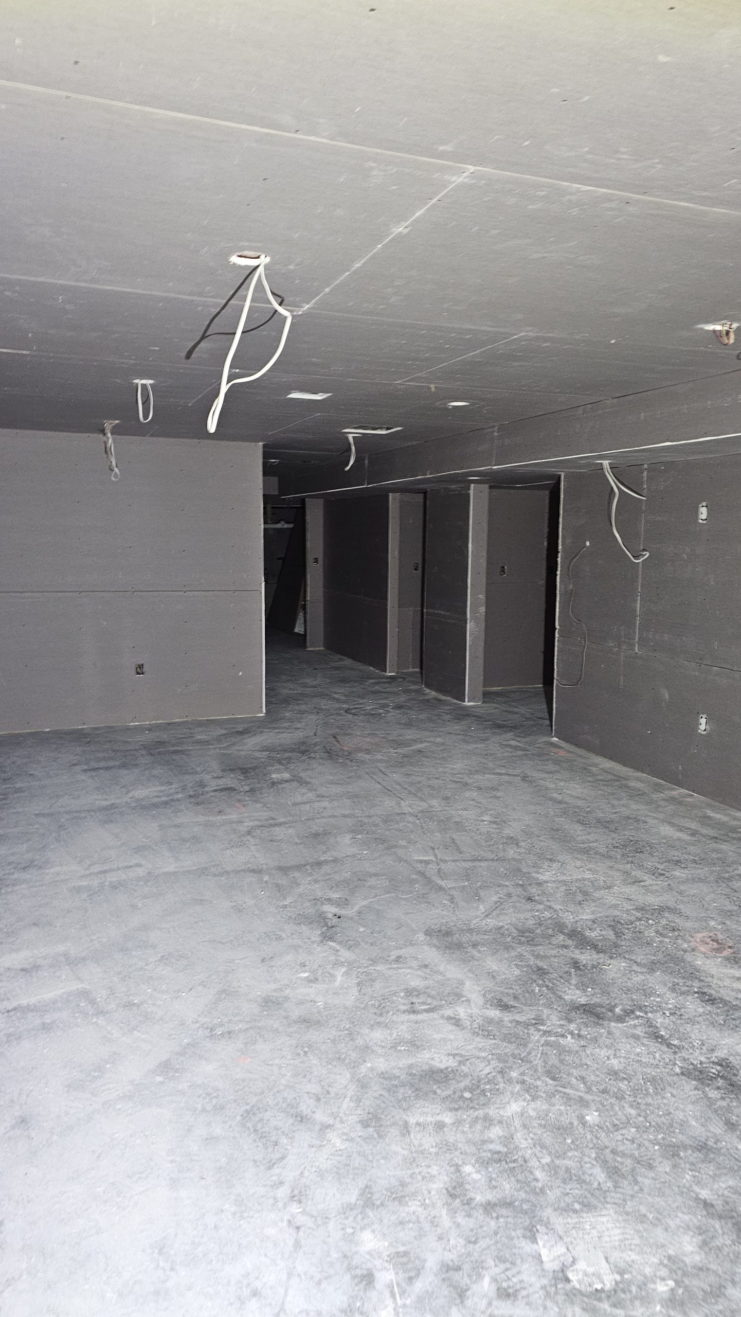 Hung drywall on Worcester basement walls and ceiling, with visible seams and fasteners before finishing.